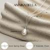 Freshwater Pearl necklace with a silver chain on a textured beige surface, featuring the brand name 'ANNIKA BELLA'.
