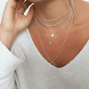 five different length necklaces styled together on a model