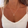 Pearl necklace worn by a women with a white top