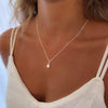 Pearl necklace worn by a women with a lace tanktop 