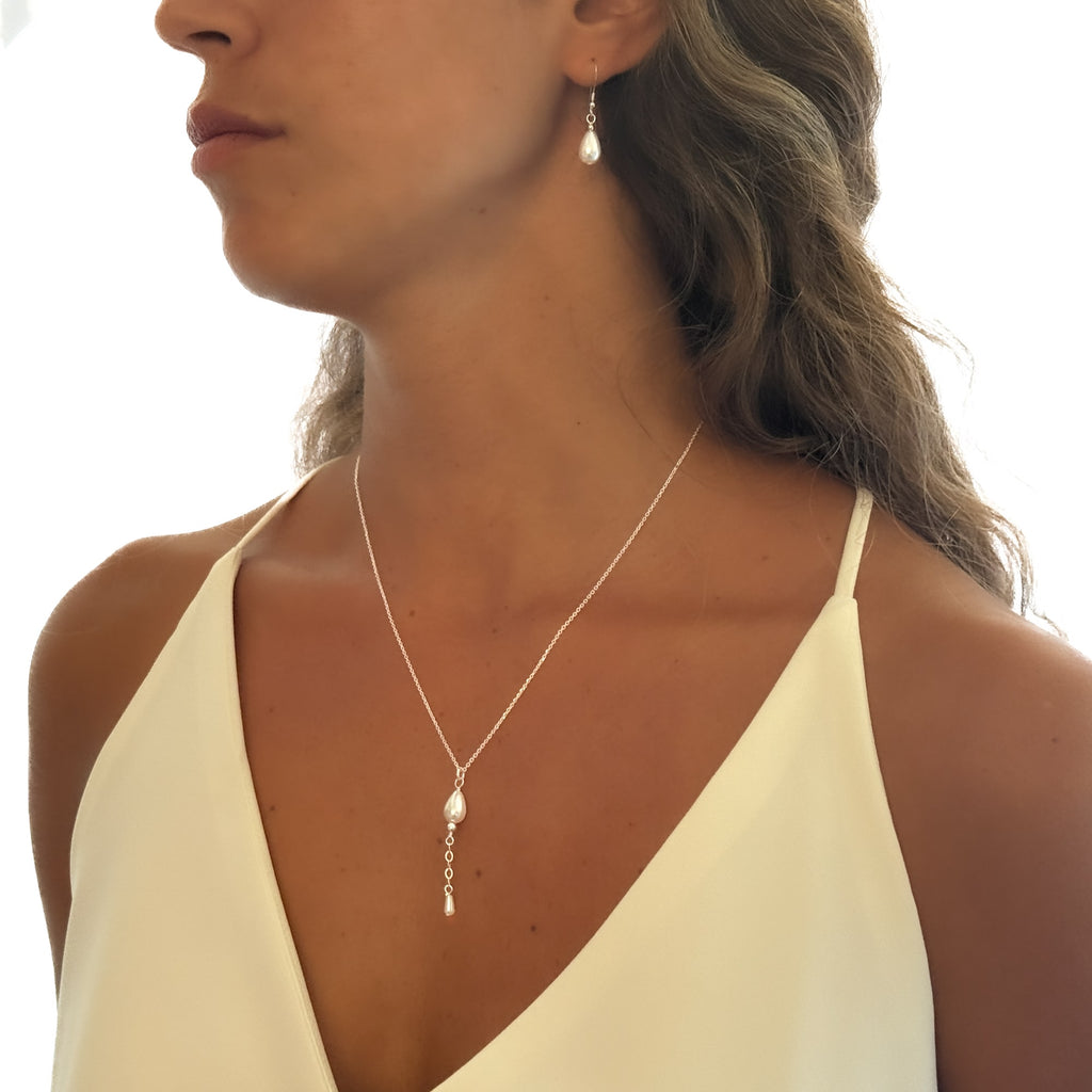 Woman wearing a delicate necklace with a white background