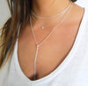 stack of 3 necklaces on a woman - a choker, a charm necklace and chain bead lariat 